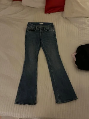 Bootcut jeans från Perfect Jeans, stl 34 - Bootcut jeans i mörkblå  från ginatricot, storlek 34. Snygga mönster på bakfickorna med unikt mönster. väldigt låg midjade och sitter perfekt, säljer på grund av att jag inte använder dom!