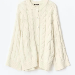 Slutsåld vit kabelstickad kofta från Gina Tricot - Säljer den här slutsålda vit kabelstickad kofta från Gina Tricot med rund hals och stora ribbade muddar. Koftan har knappar framtill och ett chunky stickat mönster. 
