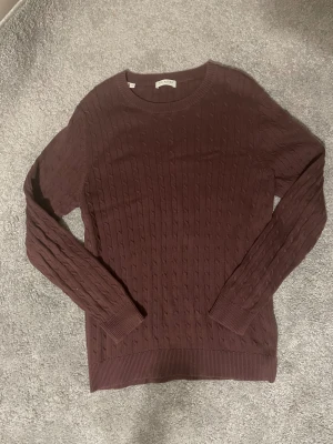 Brun stickad tröja Selected Homme - Säljer en brun stickad tröja från Selected Homme i storlek S. Tröjan har ett klassiskt kabelstickat mönster, rund hals och långa ärmar. Perfekt för dig som gillar stilrena och bekväma plagg med snygg struktur.