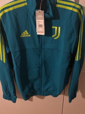 Juventus tröja - Bilderna visar en Adidas Juventus jacka, inte skor. Kan ej ge skobeskrivning eller taxonomier relaterade till skor. Pris kan bli lägre 