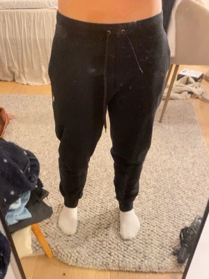Svarta mjukisbyxor Polo Ralph Lauren - Svarta mjukisbyxor från Polo Ralph Lauren med dragsko i midjan och klassisk broderad logga på låret. Byxorna har ribbade muddar vid bensluten och är tillverkade i mjukt bomullsmaterial. Perfekta för chill dagar eller när du vill vara bekväm.. Pris kan diskuteras