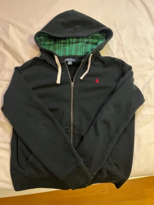 Ralph lauren hoodie Svart - Säljer denna unika Ralph lauren hoodie med grön insida i luvan. Storlek L. Skicket är 7/10 då det finns två små hål på vänster armen. (Knappt märkbara). kan gå ner i pris vid snabb affär!