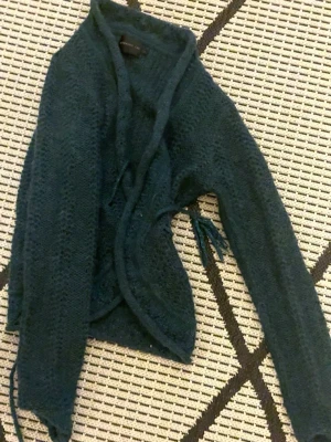 Mörkgrön stickad kofta med knyt - Säljer en mörkgrön stickad kofta från Stockholm LM i storlek M. Men jag är en Xs och den passar perfekt för mig Koftan har långärmade ärmar och ett snyggt band som man knyter med🦚