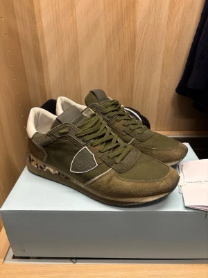 Philippe Model sneakers - Säljer ett par Philippe Model sneakers i olivgrönt. Skorna är i bra skick. Liten defekt, se sista bilden.