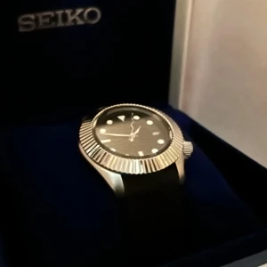 Seikomod klocka - kom gärna med bud - Säljer en nybyggd och unik klocka baserad på det välkända NH35-urverket. Klockan är 41 mm bred, har boett i rostfritt stål och en rimmad krans som ger ett unikt och stilrent uttryck.  Bygger klockor på fritiden och lägger mycket tid på varje detalj. Klockan är helt fri från damm och repor. Säljes  för att kunna finansiera fler framtida byggen. Vill sälja snabbt, kom med bud! 