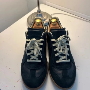 Maison Margiela gats blå mocka/läder - Snygga blåa sneakers från Maison Margiela med ovandel i både mocka och läder. Har snörat om de efter egen preferens utöver det är de i bra skick. box och dustbag medföljer. Hör av dig vid eventuella frågor!