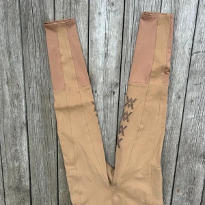 Beige ridbyxor från CRW, stl 40 - Snygga beige ridbyxor från CRE i stretchigt material. Byxorna har halvskoda längs låren. Perfekta för ridning och sitter skönt med en tight passform.