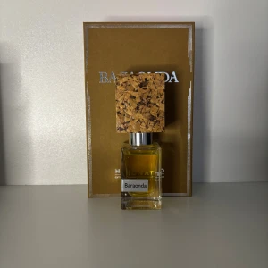 Nasomatto Baraonda parfym - Unik parfym från Nasomatto, Baraonda, i en stilren glasflaska med fyrkantigt korklock i naturkork. Doften är varm och djup, perfekt för dig som gillar exklusiva och nischade parfymer. Flaskan har en lyxig känsla och levereras med originalkartong.