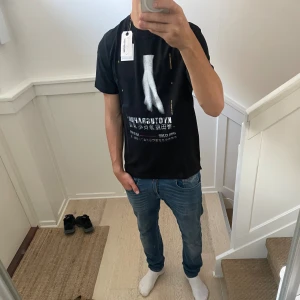 Zadig&voltaire T-shirt  - Svart t-shirt från zadig&voltaire med coolt grafiskt tryck framtill och text i vitt och rött på ryggen. Klassisk passform med korta ärmar och rund hals. Materialet är mjuk bomull, perfekt för dig som gillar en avslappnad stil med unik design.