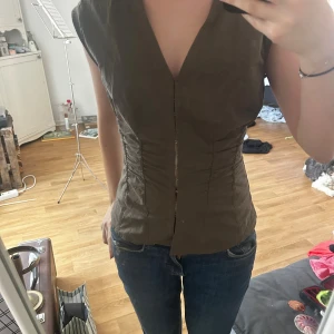 Khakigrön topp - Weekday - Grön/khaki figursydd topp/blus från Weekday med spännen framtill, strl 36, men mindre i storleken så skulle säga mer en XS. Fint skick 🌟