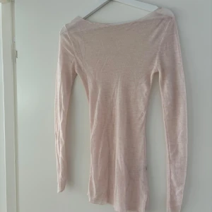 Intimissimi liknande tröja - En tunn, ljusrosa stickad tröja med lång ärm och smal passform. Perfekt för lager-på-lager och enkel att matcha med olika outfits. Tröjan har en klassisk rund halsringning och är gjord i ett mjukt material.