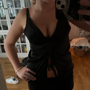 Knyt topp svart - Säljer denna jättefina silkestopp med snören man knyter fram. Den är från shein och är aldrig använd. 