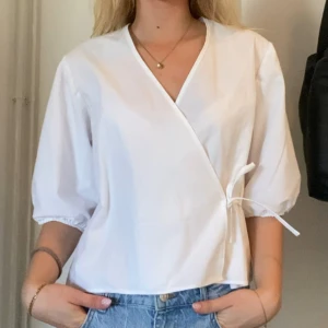 Vit omlottblus med knyt - Vit knyt-blus med puffiga ärmar! Handsydd av mig så inget märke på denna. Endast använd en gång så i bra skick! OBS!! Tar även beställningar på denna i olika storlekar så skriv PM om intresserad!🤩