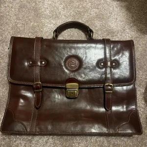 Brun portfölj i skinn från Vezzano - Klassisk brun portfölj från Vezzano i äkta skinn! Portföljen är lite smutsig inuti. 