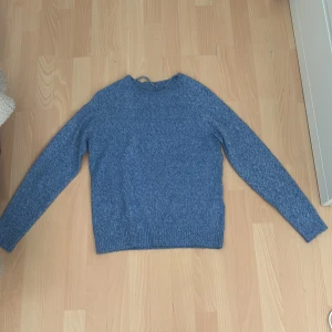 Blå stickad tröja från Vero Moda XS - Mysig blå stickad tröja från Vero Moda i storlek XS. Tröjan har rund halsringning, ribbade muddar och lång ärm. Perfekt för lager-på-lager och chill dagar. Enkel och stilren design som funkar till det mesta.