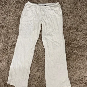 Vita linnebyxor från H&M Divided - Säljer ett par vita linnebyxor från H&M Divided i storlek S. Byxorna har rak passform, resår i midjan och snörning framtill. Materialet är en blandning av linne och viskos vilket gör dem lätta och luftiga. Perfekta för varma dagar.