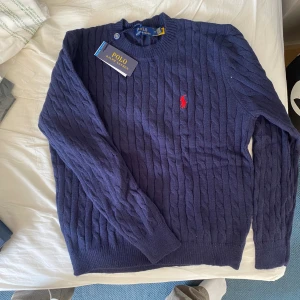Blå Polo Ralph Lauren stickad tröja - Blå stickad Polo Ralph Lauren tröja Helt ny med prislappen kvar (endast provad) inga skador.  Strl M