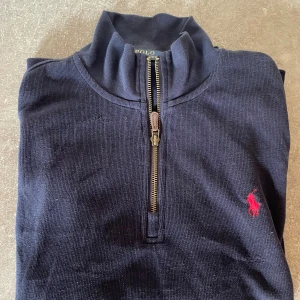 Ralph Lauren quarter zip - Säljer en skön raffe quarter zip i navy/mörkblå färg. Säljer då jag växt ur den, alltså inge skador eller likande på plagget. Storlek M. Skriv för fler bilder och tveka inte att ställa frågor. Obs. Andra bilden blev uppochner.  Priset inte hugget i sten. 