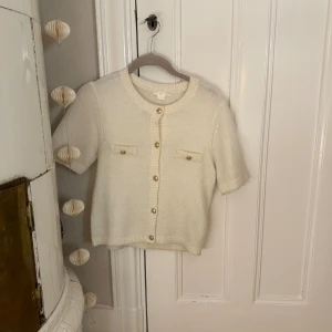 Vit stickad tröja gina - Kortärmad stickad tröja med guldiga knappar från Gina tricot. Knappt använd!😊