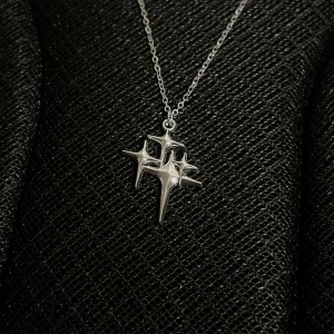 Celestial Constellation - 	•	Kedja: 50 cm 	•	Hängsmycke: 2 x 2 cm 	•	Rost- och nickelfritt rostfritt stål