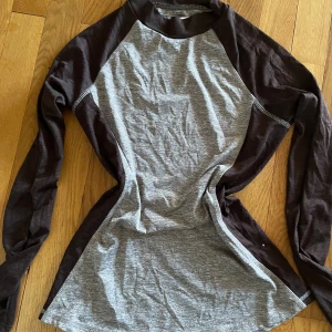 Grå och brun långärmad tröja CRW XS - Säljer en långärmad ridtröja från CRW i storlek XS. Tröjan är grå med mörkbruna ärmar och detaljer, har en klassisk raglanmodell och är tillverkad i mjuk bomull. Perfekt för dig som gillar en enkel och sportig stil.