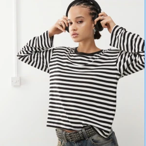 Randig långärmad tröja från Monki - Säljer en svartvit randig långärmad tröja från Monki i storlek L. Tröjan har klassiska horisontella ränder och en rund halsringning med svart kant. Perfekt för en chill och stilren look. 