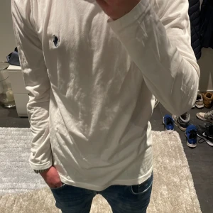 Vit långärmad tröja från Ralph Lauren - Vit långärmad tröja från Ralph Lauren. Perfekt nu inför lite kallare väder! Modellen är ca 180cm lång. Hör av dig vid funderingar!