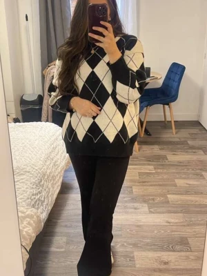 Svartvit rutig stickad tröja Alicedudu - Säljer en oversized stickad tröja från Alicedudu i storlek L. Tröjan har ett snyggt rutigt argylemönster i svart och vitt, rund hals och långa ärmar. Perfekt för dig som gillar en loose fit och vill ha en trendig look till höst och vinter.