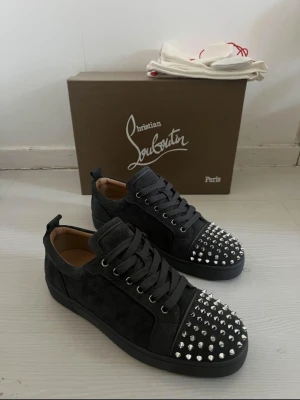 Christian Louboutin grey - |Christian Louboutin Louis Junior Spikes suede sneakers| | Storlek: 42-43 Skick: 9/10| Medföljer: 2 dustbag spikpåse och extra skosnören| Frågor eller funderingar tveka inte på att höra av dig!