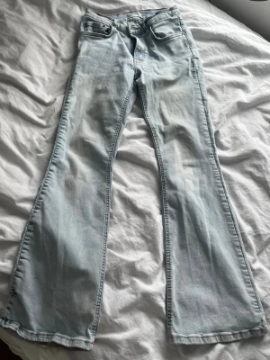 Ljusblå bootcut jeans från Perfect Jeans - Säljer ett par ljusblå bootcut jeans från Gina Tricot i storlek 36. De har klassisk femficksdesign, bootcut-ben och är tillverkade i mjukt denimtyg. Perfekt för dig som gillar en retroinspirerad look med utsvängda ben.