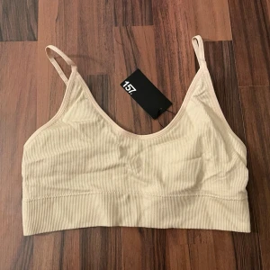 Beige ribbad bh Lager157  - Oanvänd beige bh från lager157, strl S. Färgen säljs inte längre i butik. Frakt på 55kr tillkommer (Postnord blå påse S) Bekväm passform, rund halsringning och justerbara axelband. Ribbad struktur Stretchig kvalitet Fodrad framsida Bygellös Utan knäppning Utan vaddering