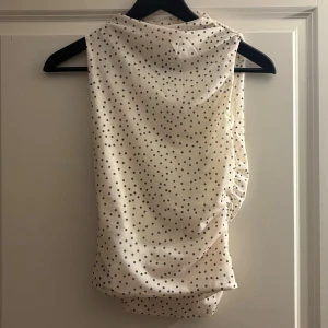 Prickig ärmlös topp från Pull&Bear - Säljer en vit ärmlös topp från Pull&Bear med svarta prickar. Den är en S men var för liten på mig, så skulle säga att det är som en XS❤️