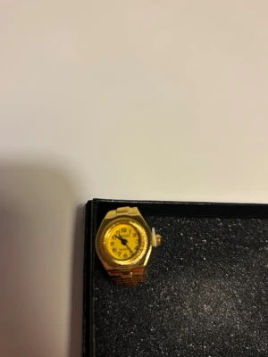 Guldig ringklocka - En guldfärgad ring med inbyggd klocka. Passar till alla tillfällen, stilren och oanvänd. Justerbar storlek.