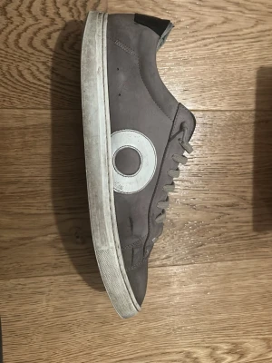Gråa Oliver Cabell sneakers - Säljer ett par grå sneakers från Oliver Cabell som är väl använda och har sina skavanker men fungerar som vardagsskor. Därav priset lite billigare. Materialet är läder och de kommer med originalkartong och dustbag. Perfekt för dig som gillar stilrena och snygga sneakers. Hör av er vid funderingar! 