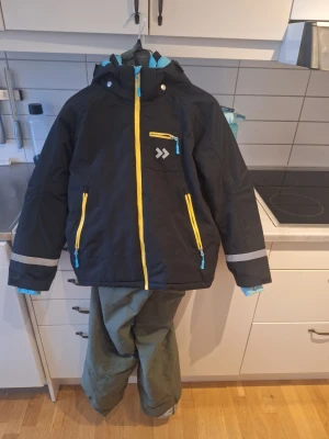 Gröna täckbyxor för vinteraktiviteter - Säljer ett par gröna täckbyxor och jacka från lager 157.Jackan är stl 150 och byxorna 160.  Dom är perfekta för kalla dagar och vinteraktiviteter.  Jackan är använd 2 gånger och byxorna 5-6 gånger. Mycket fint skick 