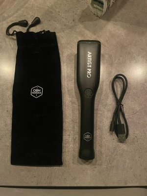 Artist Pro sminkborste från OBH Nordica - Elektrisk sminkborste i svart från OBH Nordica, modell Artist Pro. Borsten har ett stilrent handtag och kommer med en svart tygpåse med dragsko samt USB-laddningskabel. Perfekt för att applicera foundation eller puder med jämnt resultat.