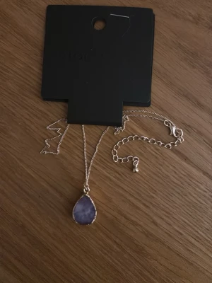 Halsband mq stocklm  - Halsband med en lila sten.