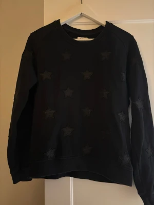 Svart sweatshirt med stjärnor - Cool svart sweatshirt med upphöjda stjärnor över hela tröjan. Använd men inget som syns. Kan passa för storlek S också.