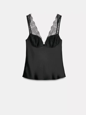 Svart linnetopp med spetsdetaljer - Säljer en svart linnetopp med djup v-ringning och tunna axelband. Toppen har snygga spetsdetaljer vid halsen och kuporna, vilket ger en lyxig känsla. Materialet är glansigt och lent, troligen satin eller polyester. Perfekt för dig som gillar en stilren och trendig look. Nypris är 400kr.
