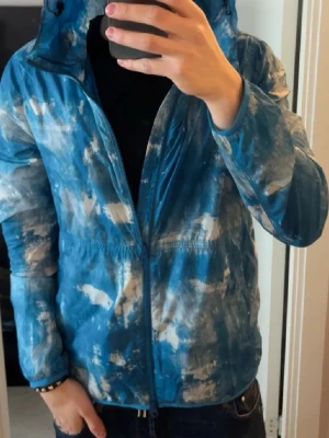 Blå mönstrad vindjacka Woolrich - Säljer en riktigt snygg blå vindjacka från Woolrich. Modellen är 182cm väger 65kg alltså sitter mer Som M en Lpriset ej hugget i sten kom med bud  