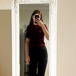 Vinröd stickad kortärmad tröja - Vinröd stickad tröja med korta ärmar och rund hals. Snygg, enkel och figurnära modell som passar perfekt till jeans eller kostymbyxor. Mjuk och skön känsla, perfekt för lager-på-lager under hösten eller våren.