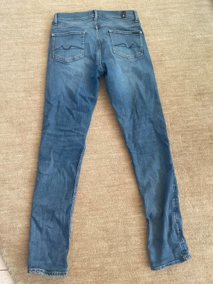 7 for all mankind jeans  - Säljer nu dessa tvärfeta jeans från 7 for all mankind. Nypriset: 4000. Mitt pris: 799. Jeansen är sparsamt använde och har inga större tecken på användning (skick: 8,5-10). Säljes pågrund av att de är för små. Jeansen är i en blå färg. Passform: slimfit. Tveka inte på att höra av dig vid minsta fundering!