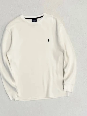 Vit långärmad tröja Polo Ralph Lauren - Vit långärmad tröja från Polo Ralph Lauren i 100% bomull med klassisk rund hals och broderad logga på bröstet. Tröjan har en ribbad struktur och muddar vid ärmslut. Perfekt för chill dagar och enkel att matcha med jeans eller mjukis.