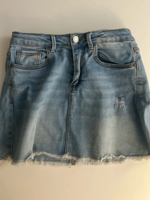 ljusblå jeanskjol från zara  - super snygg jeanskjol från zara med en fransad nederkant, samt en liten sliten patch på framsidan för extra cool vibe. den ser ganska lång ut men tycker faktiskt inte att den gör det på💕säljer pågrund av att den inte passar längre. midjemått: 34cm. längd: 33