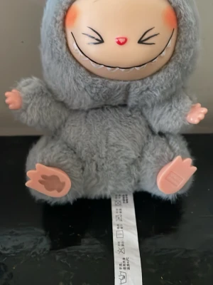 Grå pälsväst med fluffig look - Säljer en grå pälsväst med superfluffigt material som ger en mysig och cool vibe. Västen har en rund form och är helt täckt av mjuk pälsimitation. Perfekt för dig som vill sticka ut med en unik och trendig stil.