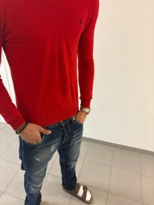 Röd tröja från Ralph Lauren - Snygg röd u-ringad tröja från Ralph Lauren med loggan broderad på bröstet!