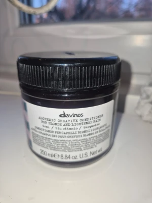 Davines Alchemic Creative Conditioner Teal - Davines Alchemic Creative Conditioner för blont och ljusat hår i färgen teal. Kommer i en rund plastburk med svart lock, innehåller 250 ml. Balsamet har en intensiv turkosblå färg och är krämigt i konsistensen. Perfekt för dig som vill experimentera med färg på håret. Funkar både på naturligt och färgat hår för att ljusa upp det. Endast provat på en slinga, nyinköpt.