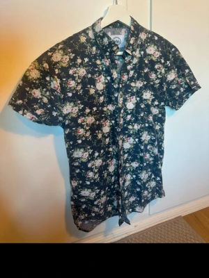 Kortärmad Skjorta - Skitsnygg kortärmad sommarskjorta som jag växt ur. Använd 1-2 gånger sommarn 22. Hängt i garderoben sen dess. Sitter bra i ärmarna.