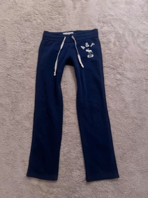 Blå lågmidjade mjukisbyxor Abercrombie & Fitch  - Blå lågmidjade mjukisbyxor i storlek xs ifrån Abercrombie & Fitch, Innerbenslängden är 74cm! 