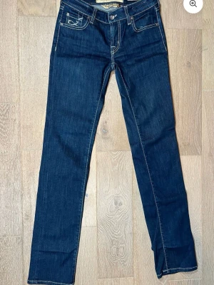 Jacob Cohen jeans - Snygga mörkblå jeans från Jacob Cohen med raka ben och kontrastsömmar. Jeansen har broderade detaljer på fickorna och en patch med logga baktill. Klassisk femficksmodell med knappstängning och exklusiv känsla. Perfekt för dig som gillar stilrena jeans med unik touch.
